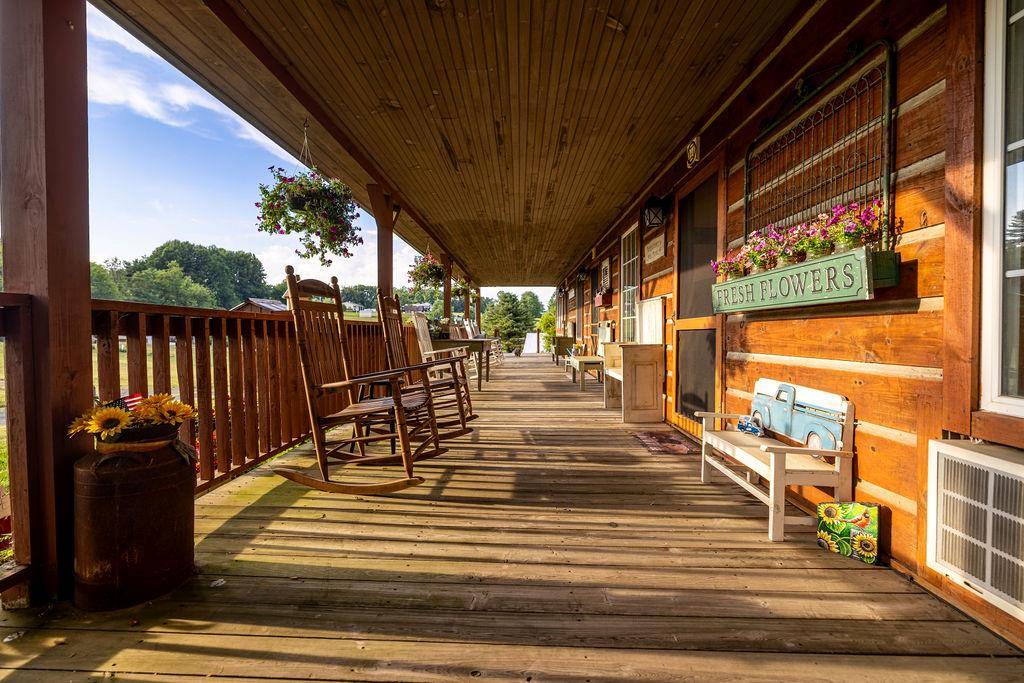 The lodge's long covered porch with rocking chairs and hanging flowers.