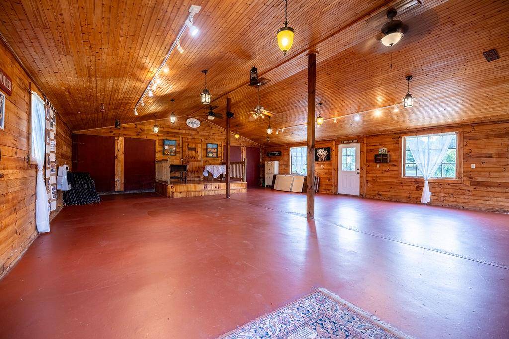 The barn's open interior with a painted wood floor and string lights (the event barn).